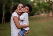 Mãe abraça filho nos braços