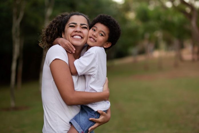 Mãe abraça filho nos braços