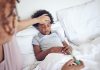 Menino afro com problemas respiratórios está deitado na cama