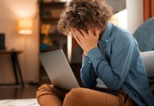 Menino esconde rosto com laptop no colo