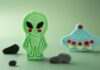 Alien verde e um disco voador azul modelados em biscuit para festa infantil.