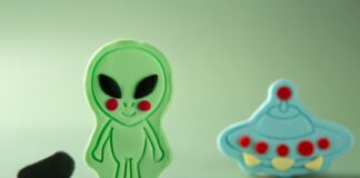 Alien verde e um disco voador azul modelados em biscuit para festa infantil.