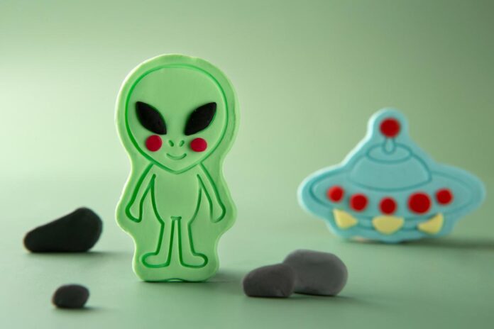 Alien Alien verde e um disco voador azul modelados em biscuit para festa infantil.