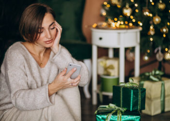 Mulher ao lado de presentes de Natal
Foto: Freepik