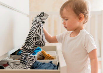 Criança retirando roupa da gaveta
Foto: Freepik