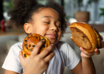 Criança comendo guloseima
Foto: Freepik